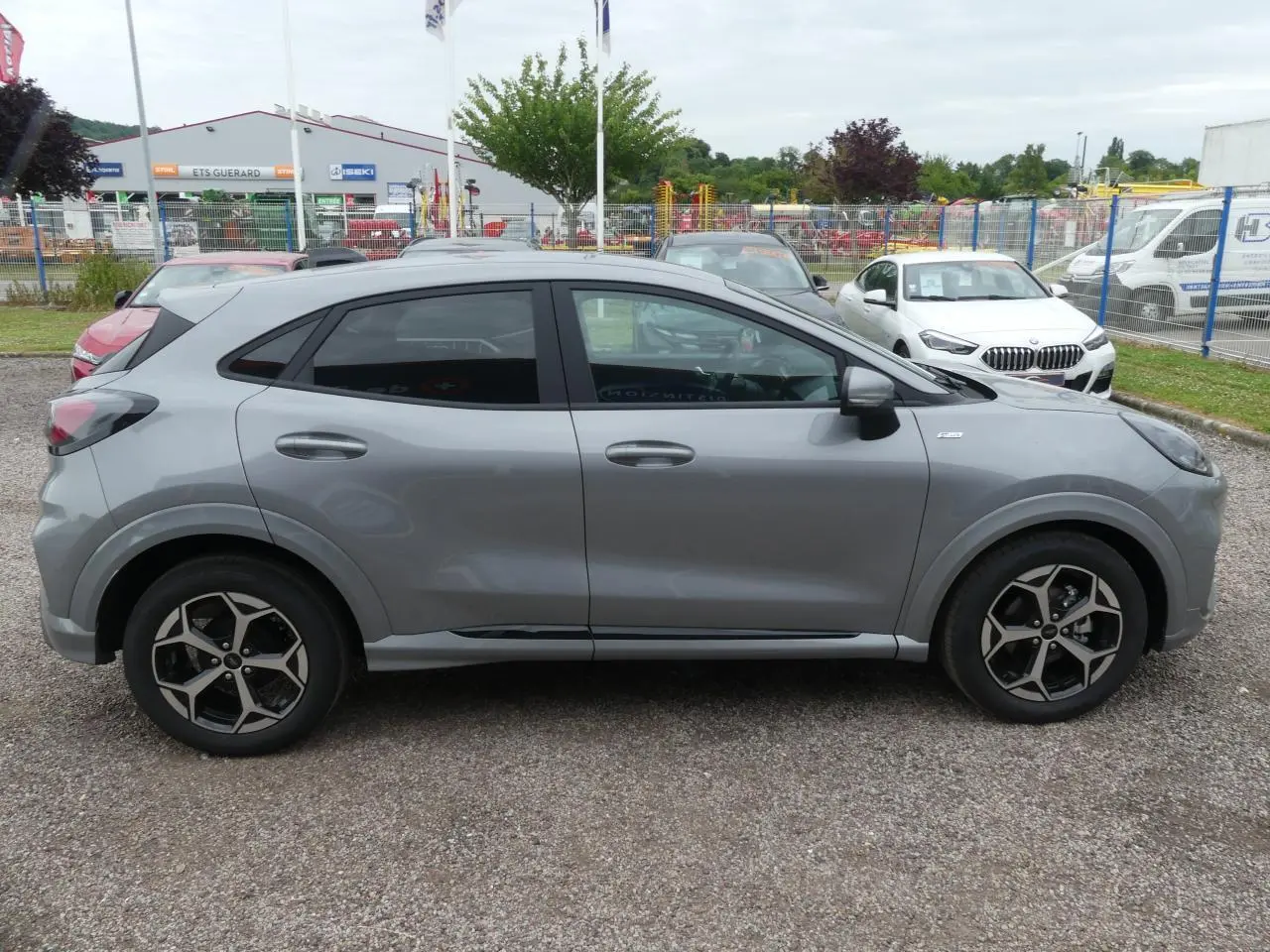 Ford Puma 2025 gris métallisé vu de profil côté gauche, avec jantes alliage 17 pouces et vitres arrière surteintées.