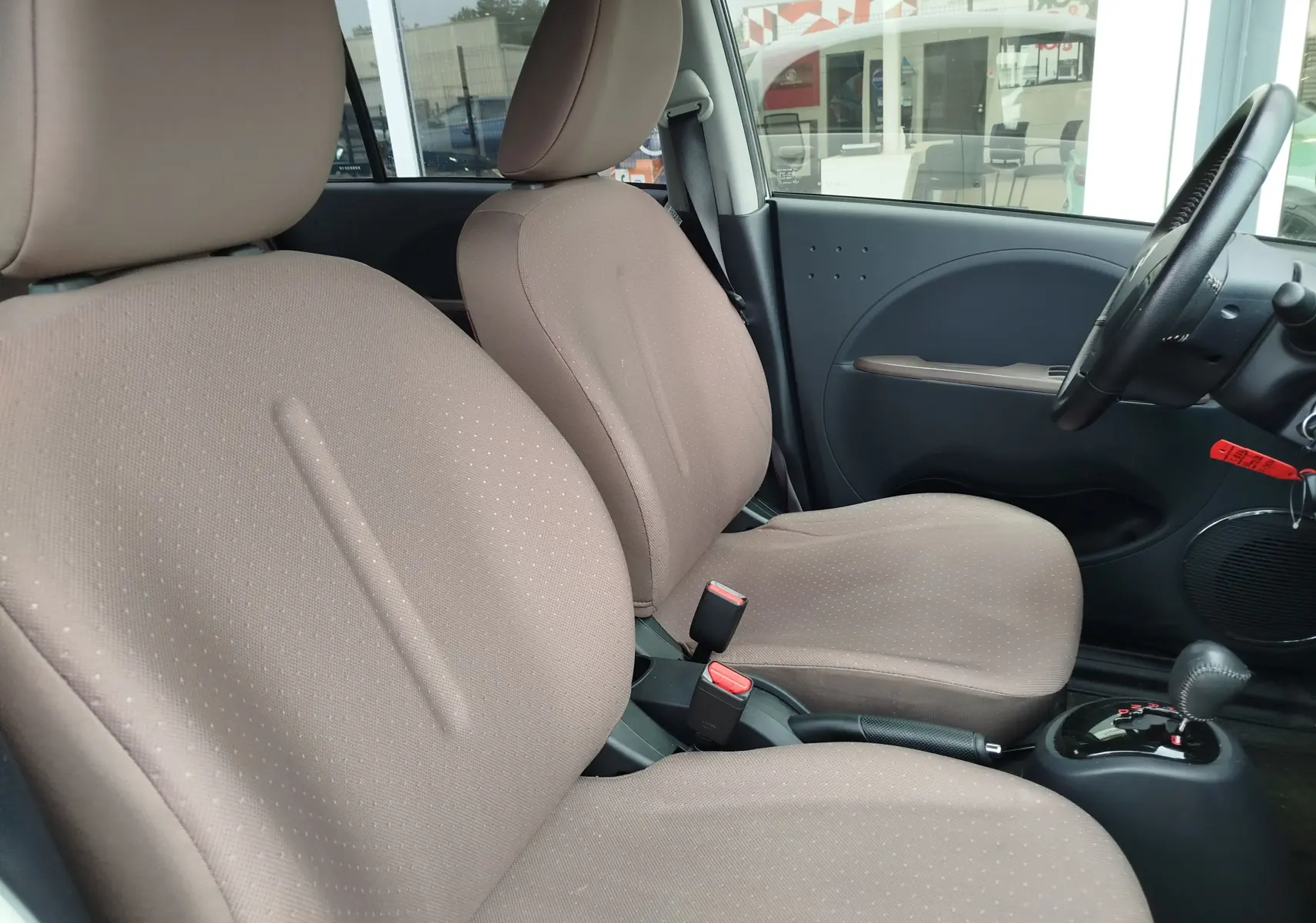 Vue intérieure côté conducteur de la CITROEN C-ZERO 2020, sièges tissu beige et tableau de bord gris foncé.