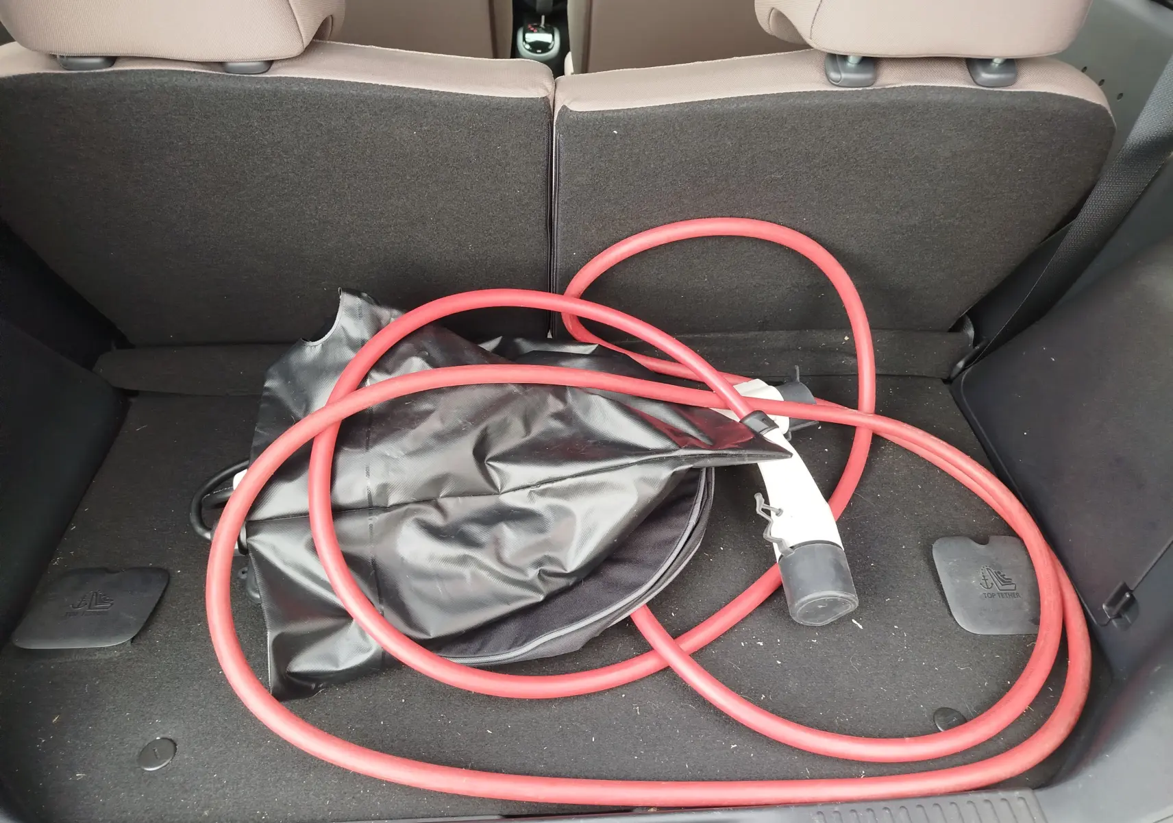 Vue du coffre arrière d'une Citroën C-Zero blanc Antarctique de 2020 avec câble de recharge électrique rouge enroulé.