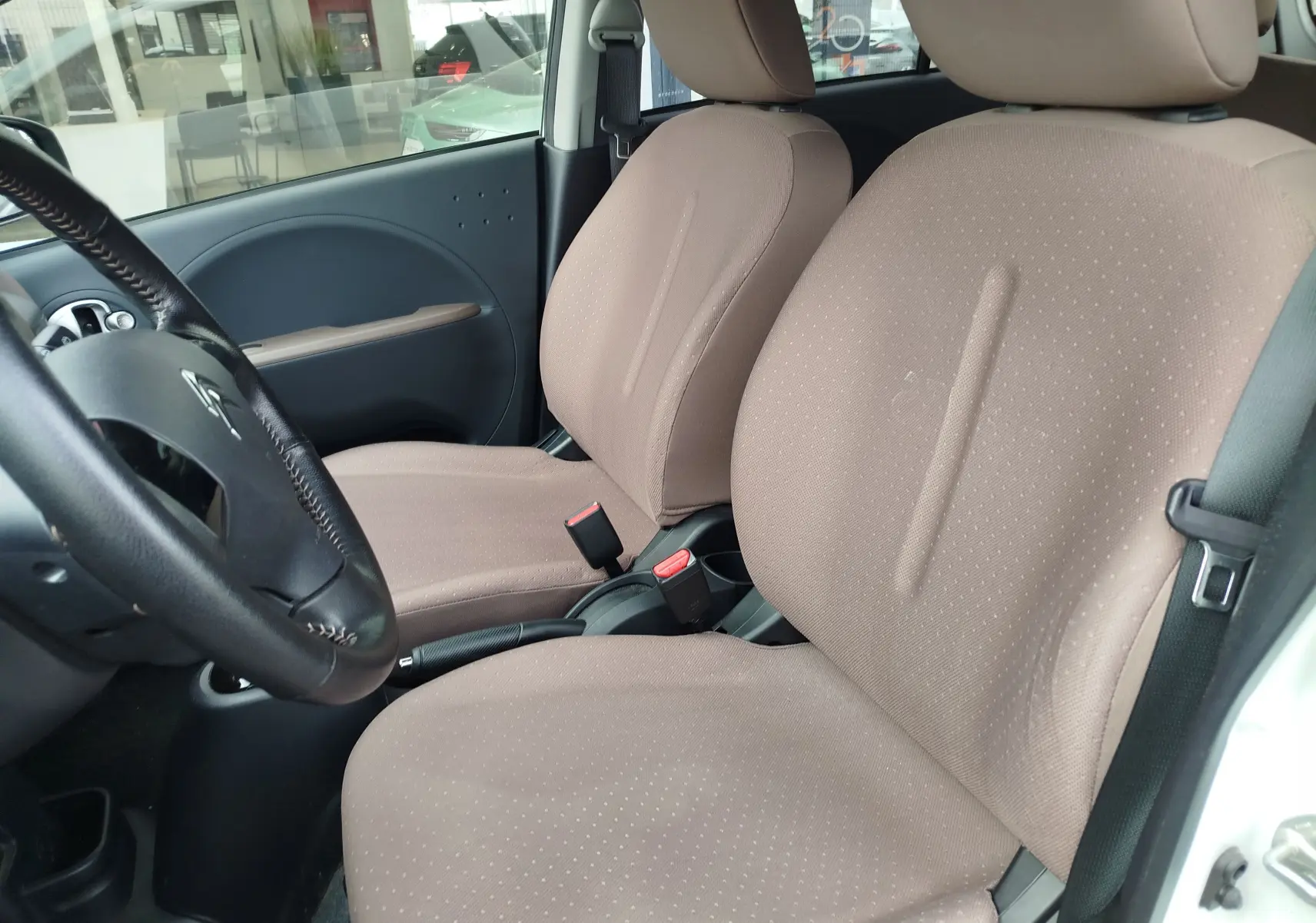Vue intérieure côté conducteur de la Citroën C-ZERO Confort 2020, sièges tissu beige et volant noir visible.
