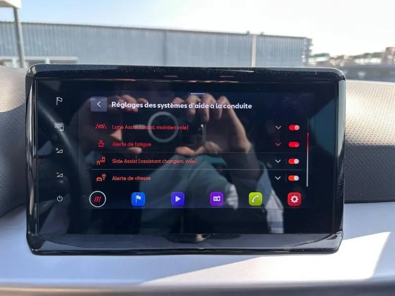 Écran tactile central du SEAT Arona 2025 montrant les réglages d’aides à la conduite avec interface sombre et icônes colorées.