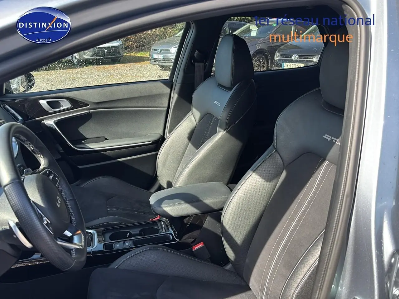 Vue intérieure côté conducteur du Kia Xceed gris 2024, sièges sport GT-Line avec accoudoir central et volant cuir multifonction.
