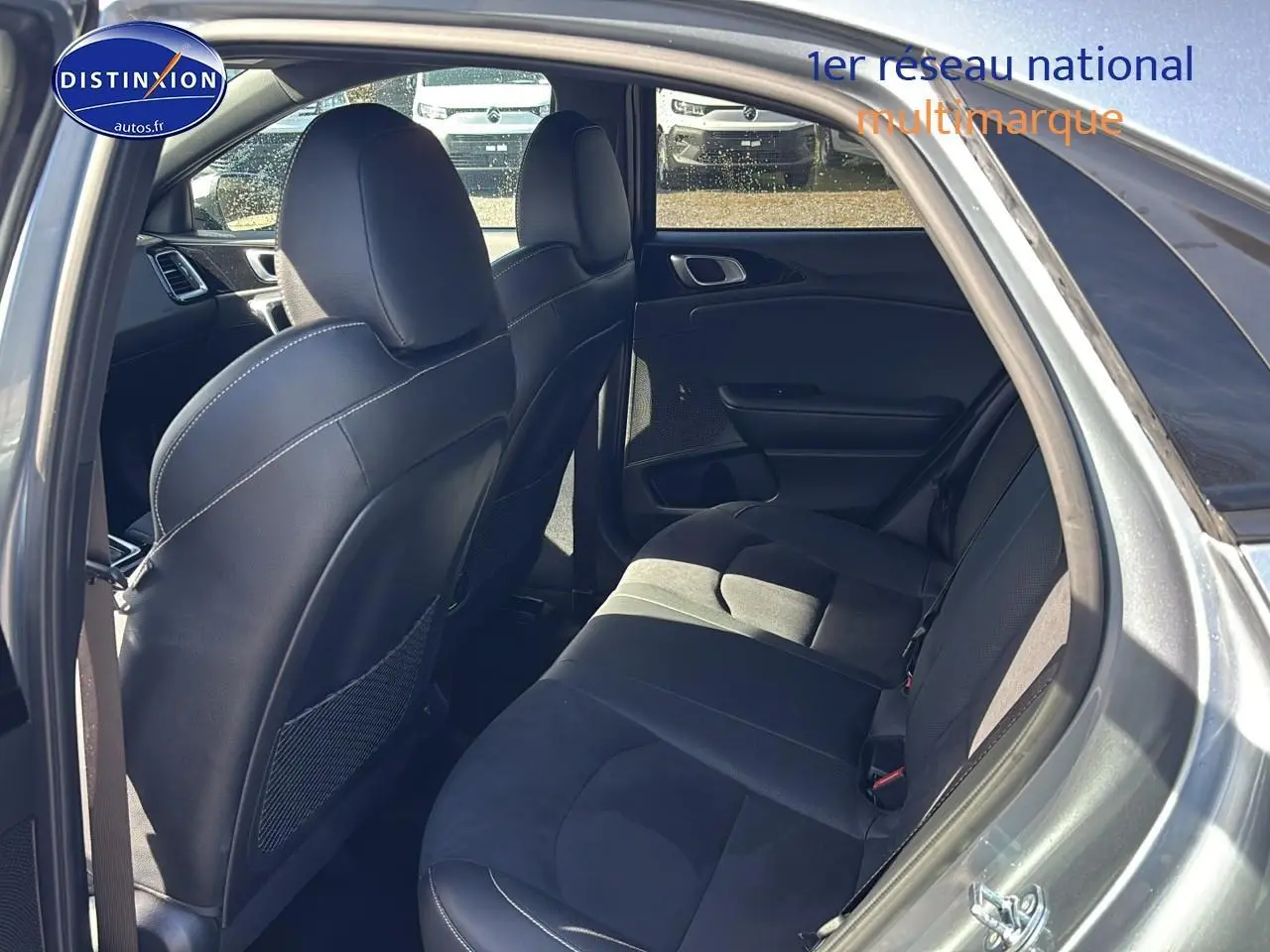 Vue intérieure côté droit montrant la banquette arrière et les sièges avant en cuir noir du KIA Xceed gris 2024.