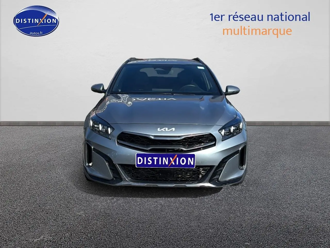 Vue avant d'un KIA Xceed gris 2024 avec calandre noire et phares LED distinctifs, sur fond neutre.