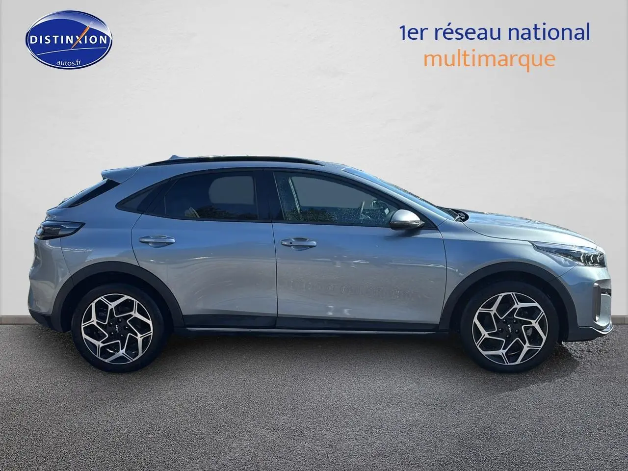 Profil droit d'un KIA Xceed gris 2024 avec jantes alliage au design géométrique et vitres arrière surteintées.