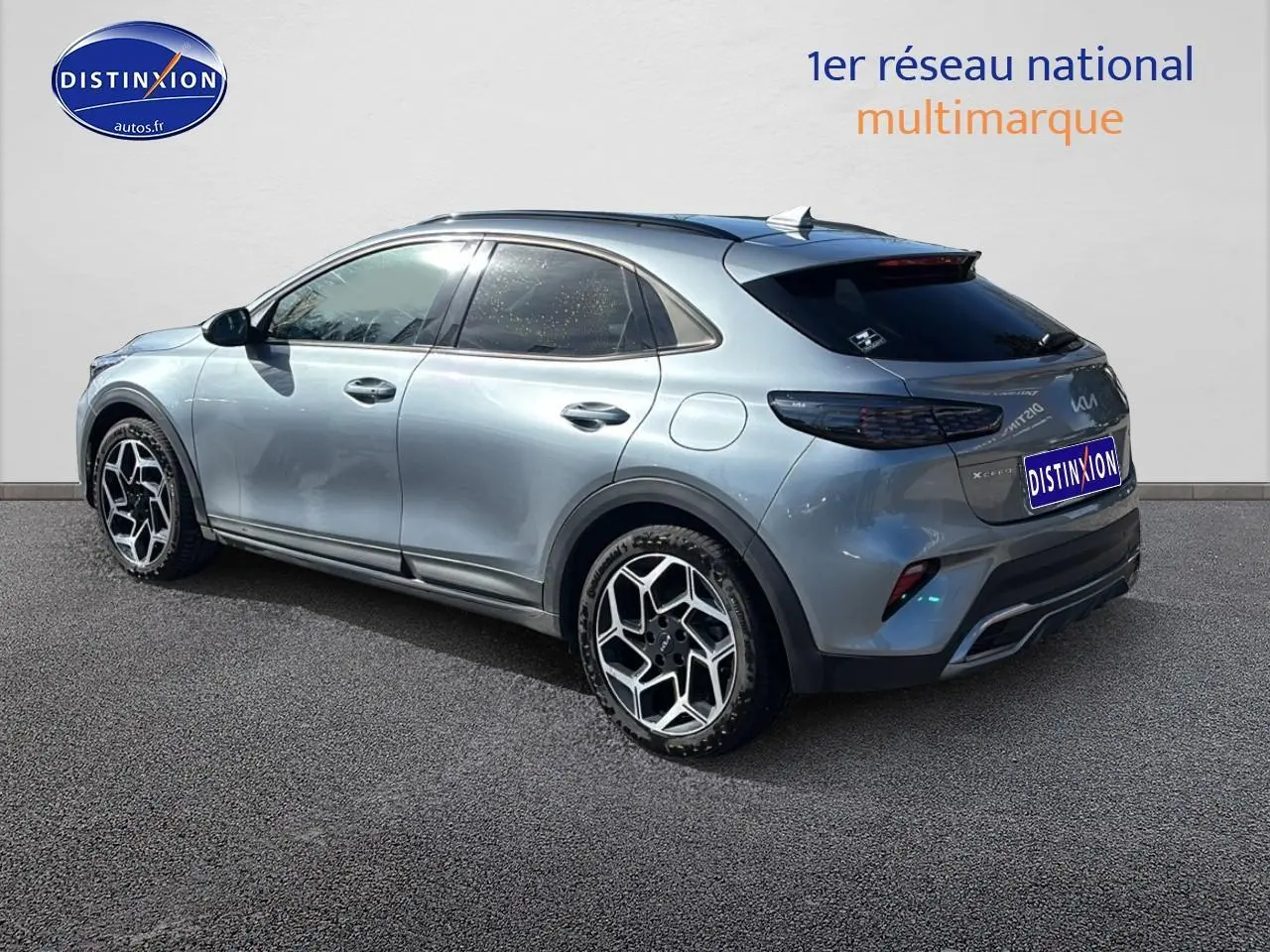 Vue 3/4 arrière droite du Kia Xceed gris 2024 avec jantes alu et vitres arrière surteintées.