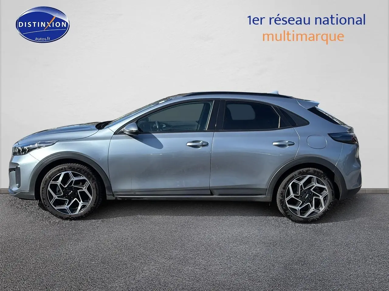 Profil côté gauche d'un KIA Xceed gris 2024 avec jantes alu au design géométrique et vitres surteintées.