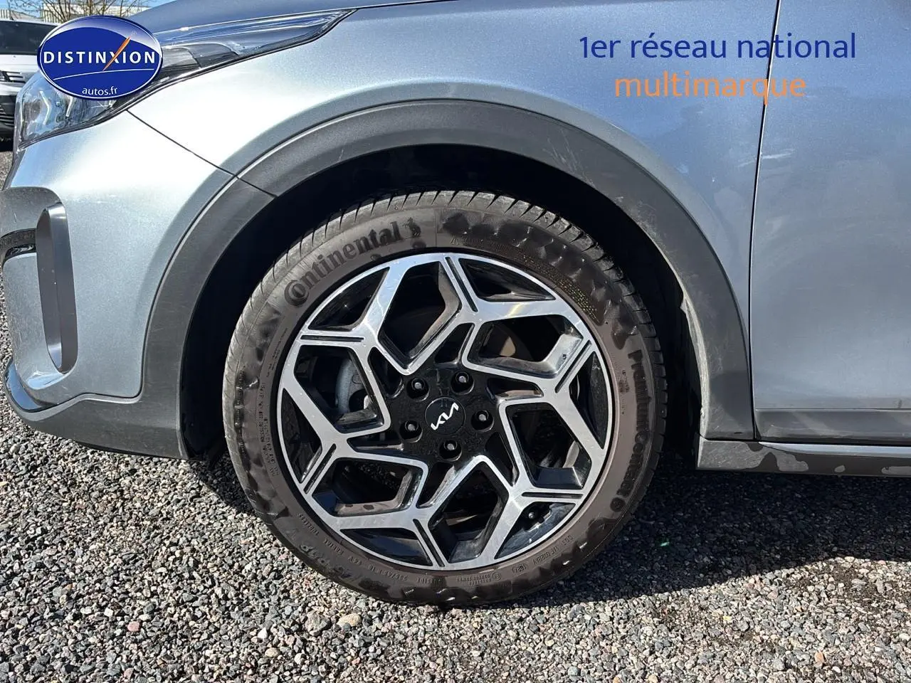 Gros plan sur la roue avant gauche avec jante alu noire et argentée du KIA Xceed gris 2024.