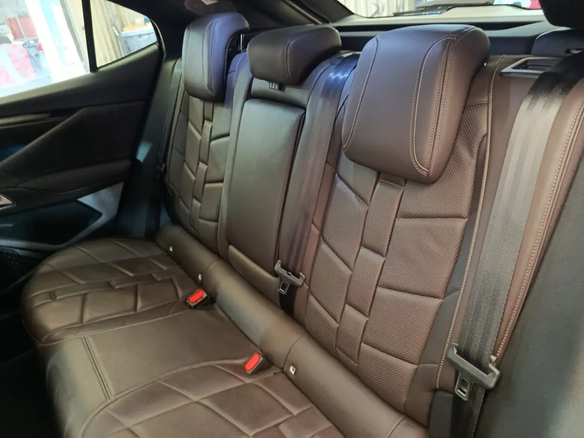 Vue intérieure des sièges arrière en cuir marron du DS4 E-TENSE 225 LA PREMIERE, côté droit, avec ceinture de sécurité visible.