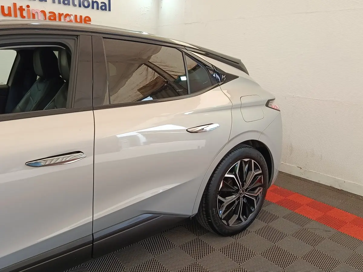 Vue côté droit arrière d'une DS4 E-TENSE 225 gris clair avec jantes noires et toit noir contrasté.