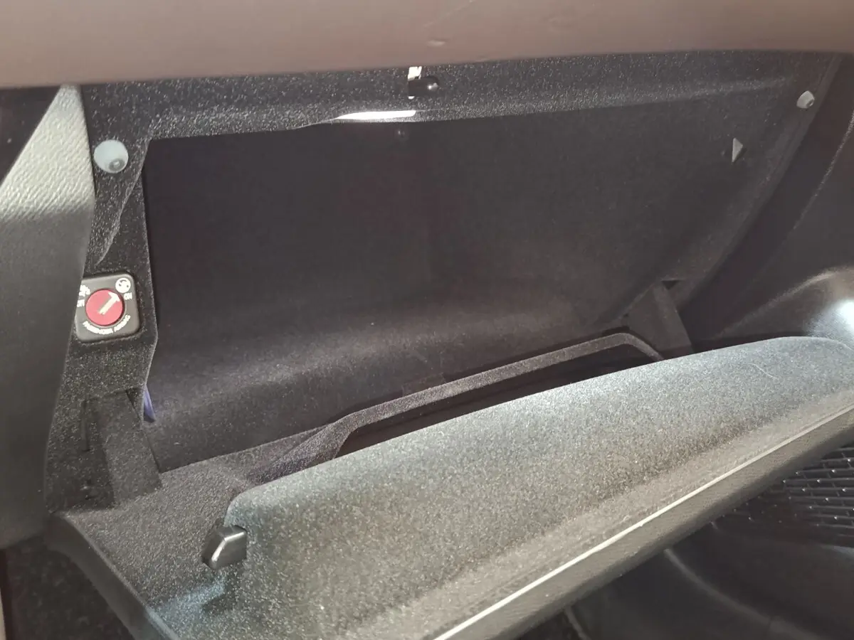 Gant de boîte à gants ouvert en tissu noir dans l'habitacle de la DS4 E-TENSE 225 gris clair, vue intérieure côté passager.