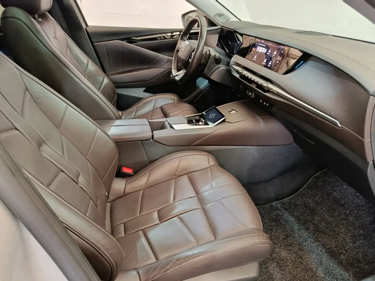 Vue intérieure côté droit du DS4 E-TENSE 225 gris clair, avec sièges cuir marron et tableau de bord digital.