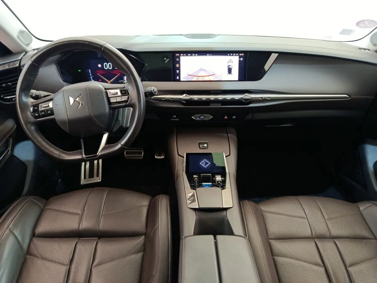 Vue intérieure avant du DS4 E-TENSE 225 gris, montrant le volant cuir, tableau de bord numérique et console centrale moderne.