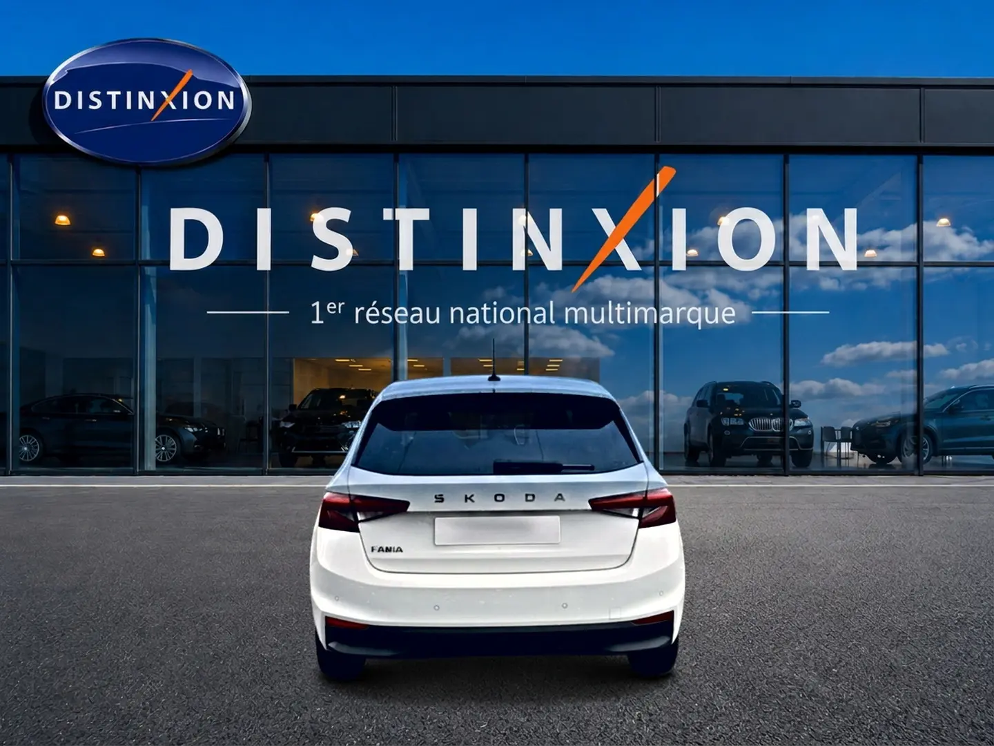 Vue arrière d'une Skoda Fabia blanche 2025 garée devant une vitrine avec logo Distinxion.