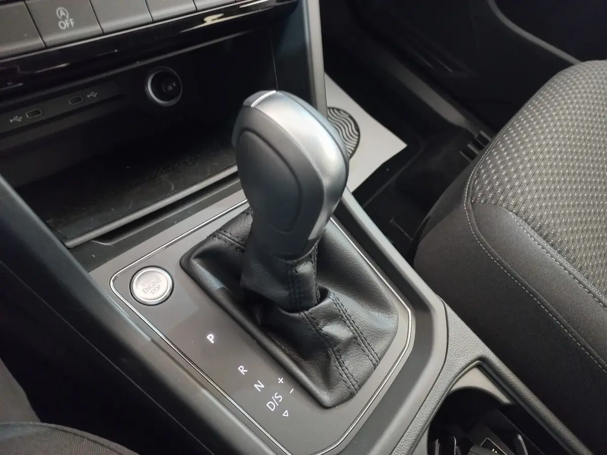 Gros plan sur la commande de boîte automatique noire du Volkswagen Touran 2024, avec bouton Start/Stop visible.