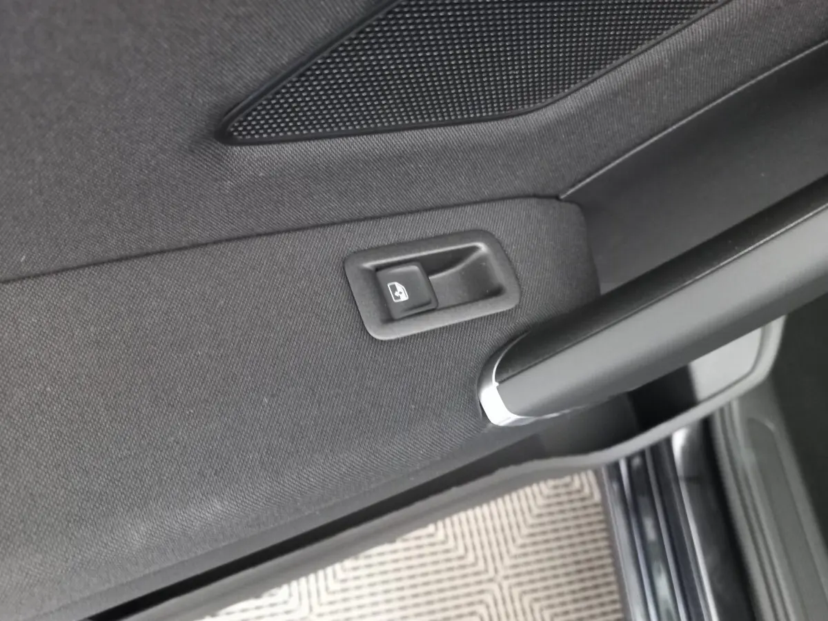 Détail de la commande de vitre électrique sur la porte intérieure côté gauche d’un Volkswagen Touran noir 2024.