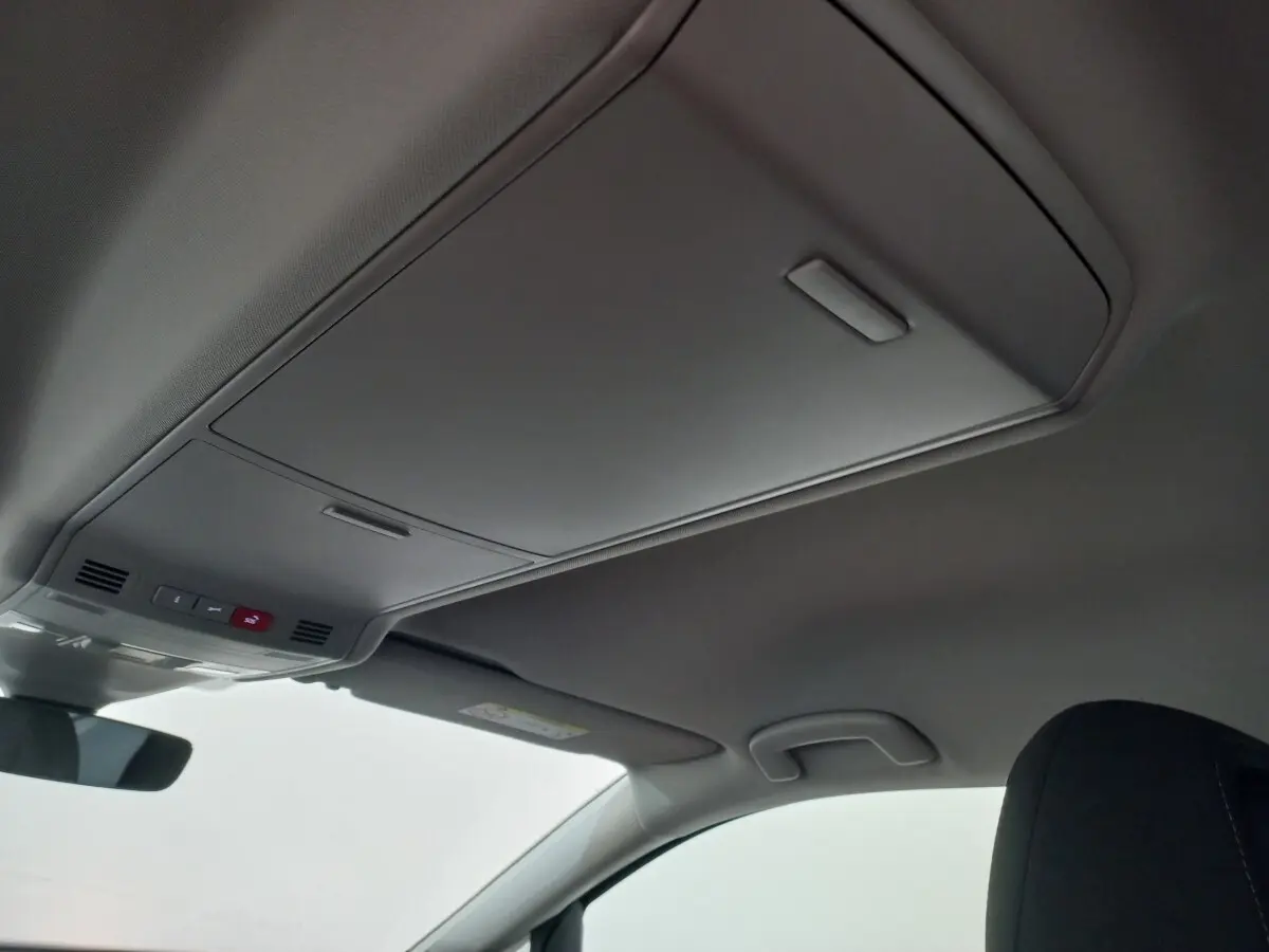 Plafonnier intérieur avec commandes d'urgence et pare-soleil côté conducteur du Volkswagen Touran noir 2024.
