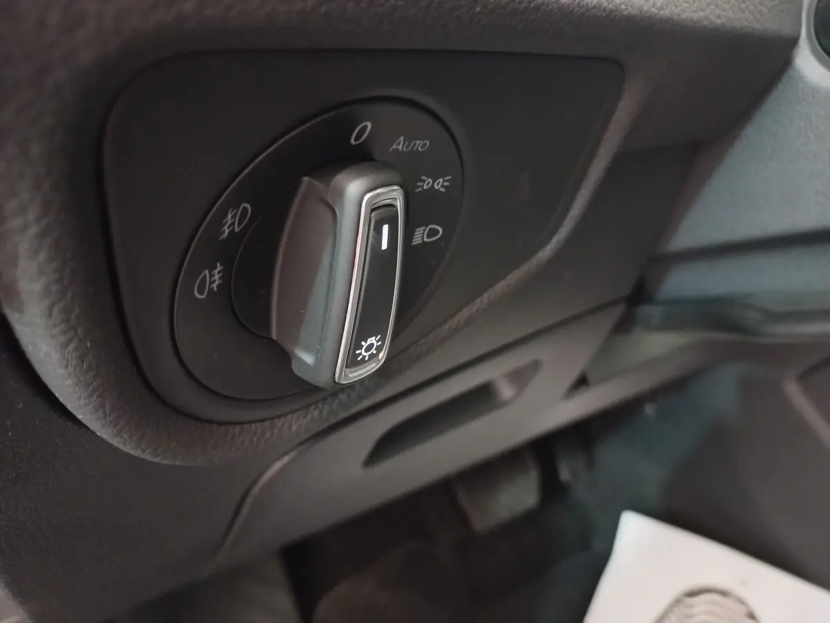 Gros plan sur la commande des phares noirs du Volkswagen Touran 2024, avec réglages d’éclairage visibles.