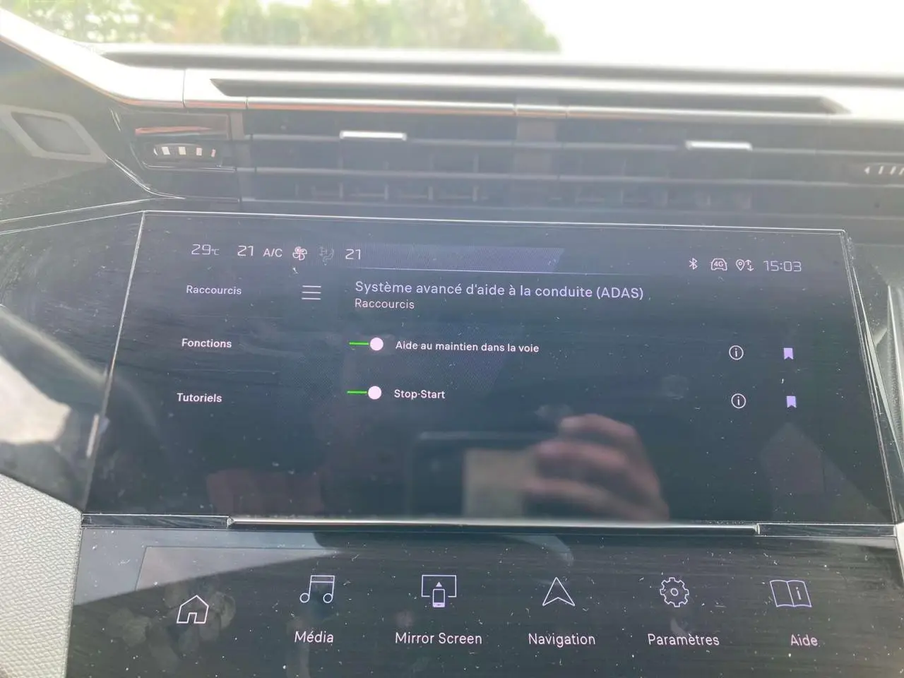 Écran tactile central de la Peugeot 308 2023 affichant les aides à la conduite dans un intérieur moderne noir.