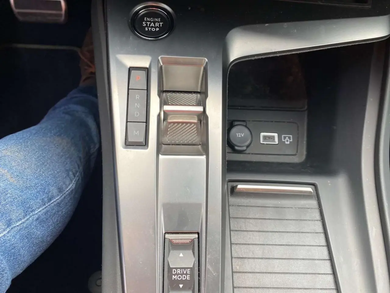 Vue rapprochée de la console centrale de la Peugeot 308 2023, avec levier de boîte auto et bouton start/stop.