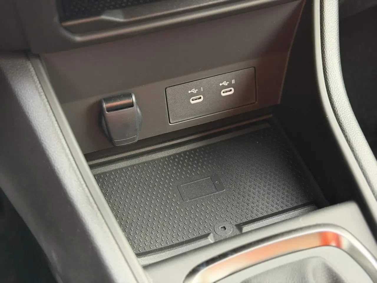 Gros plan sur la console centrale du Renault Captur 2025, montrant les prises USB-C et le chargeur sans fil.