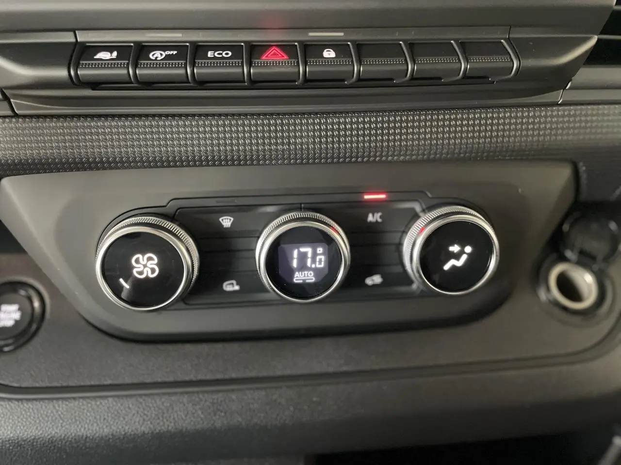 Gros plan sur les commandes de climatisation automatique du Renault Trafic Fourgon, affichant 17°C.
