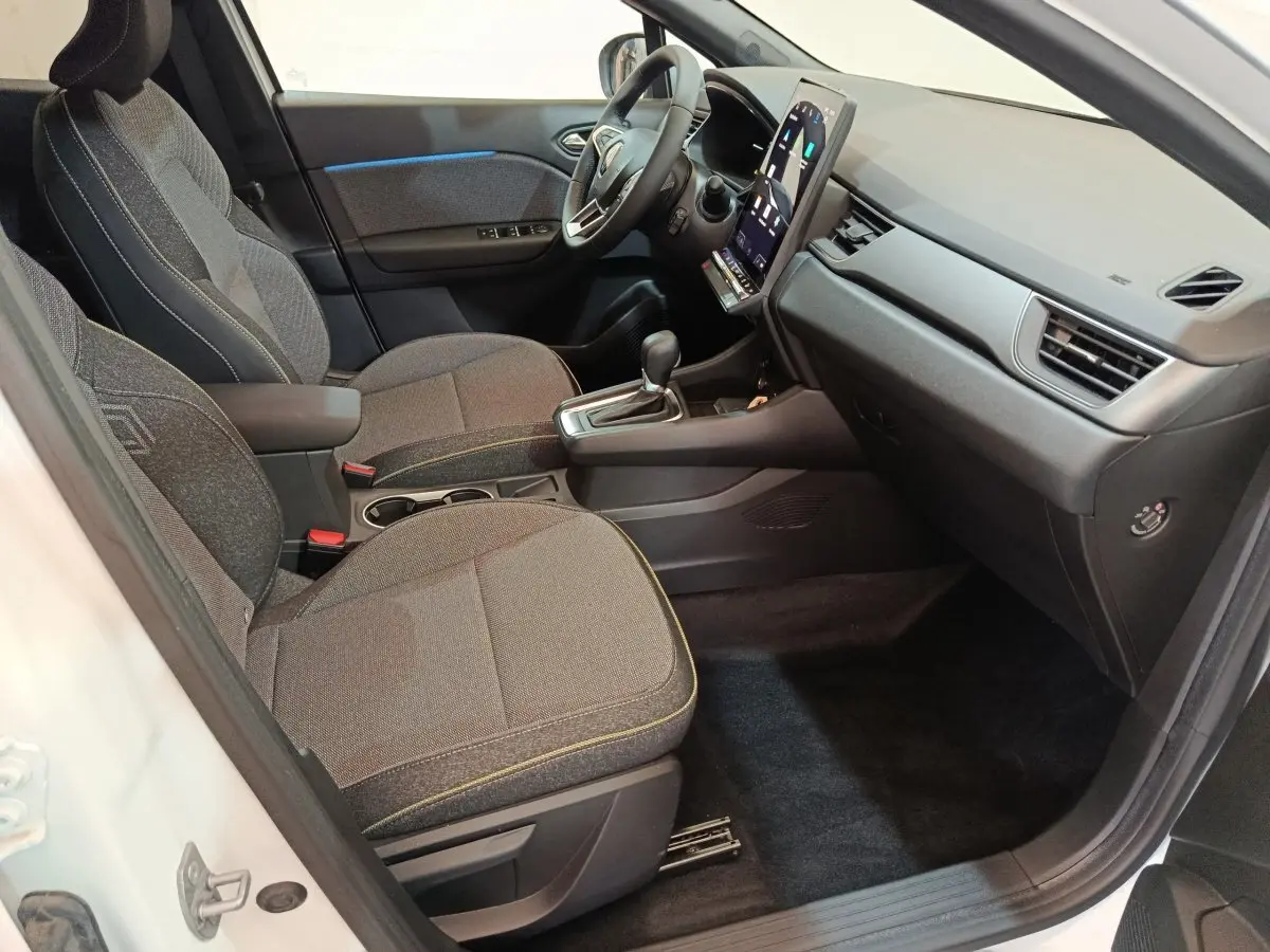 Vue intérieure côté passager du Renault Captur blanc 2025, avec tableau de bord moderne et écran tactile vertical.