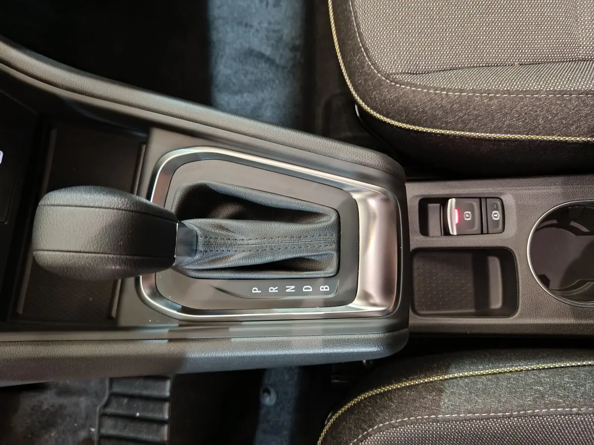 Gros plan sur la console centrale du Renault Captur blanc 2025, montrant le levier de boîte automatique et frein à main électrique.