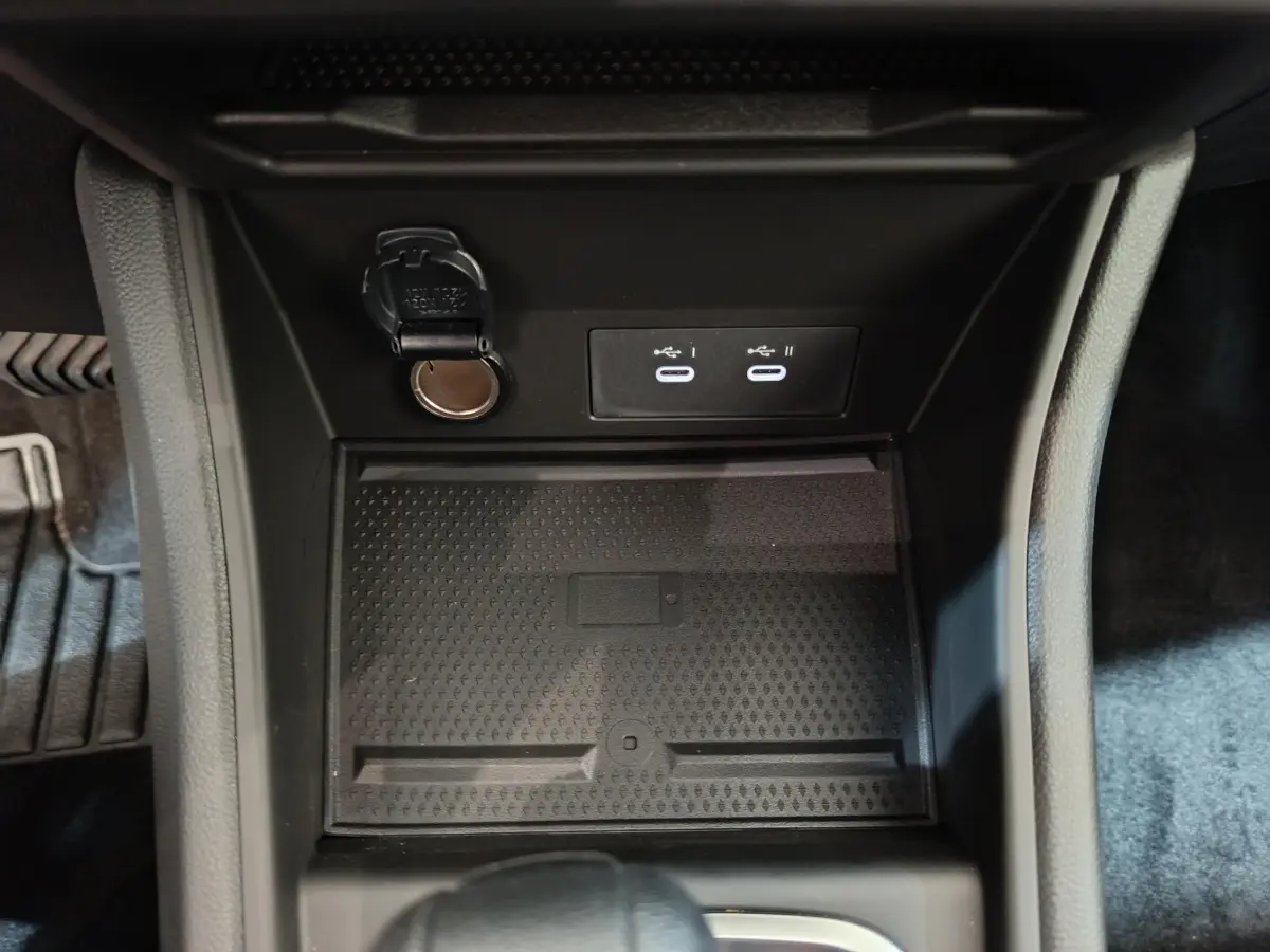 Gros plan sur la console centrale noire du Renault Captur 2025 avec prise 12V et deux ports USB-C éclairés.