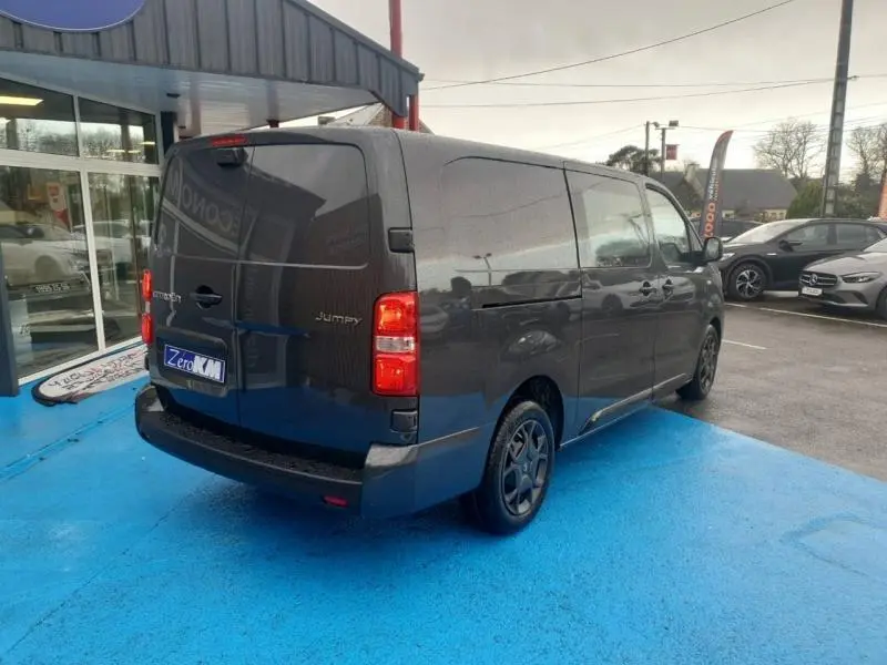 Vue 3/4 arrière droite du Citroën Jumpy gris Titane métal avec portes arrière battantes et roues noires.