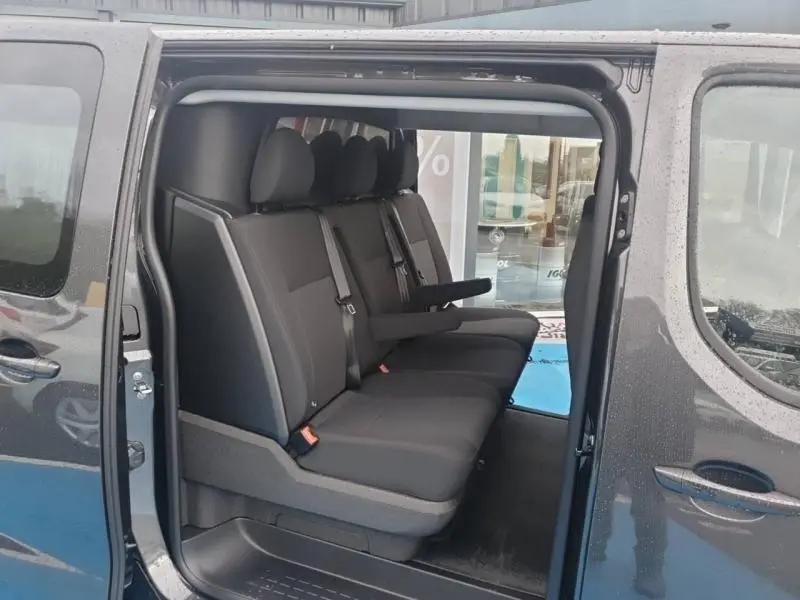 Vue latérale droite sur l’intérieur du Citroën Jumpy gris Titane avec banquette arrière trois places et accoudoir central.