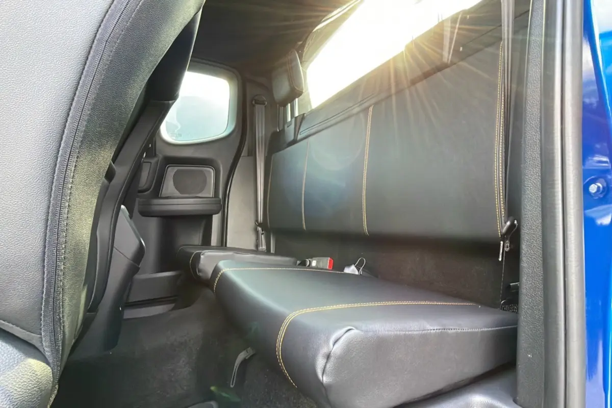 Vue intérieure arrière côté droit du Ford Ranger Wildtrak 2025 bleu lightning, banquette en cuir noir avec surpiqûres jaunes.