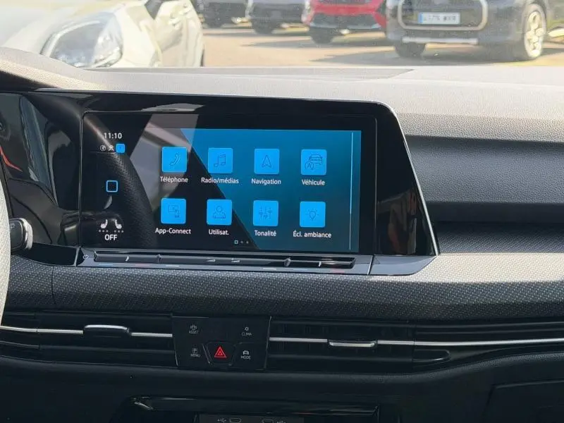 Vue intérieure du tableau de bord de la Volkswagen Golf 2024 avec écran tactile central affichant les options multimédias.