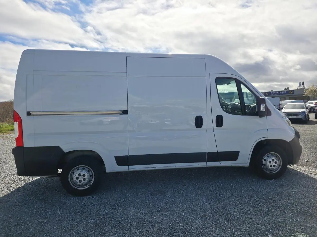 Vue de profil côté droit d’un Opel Movano Fourgon blanc 2022 avec portes latérales coulissantes et jantes tôles grises.