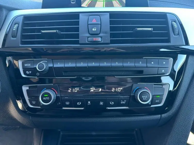 Vue rapprochée de la console centrale noire de la BMW Série 4 Gran Coupe F36 avec commandes climatisation et audio.