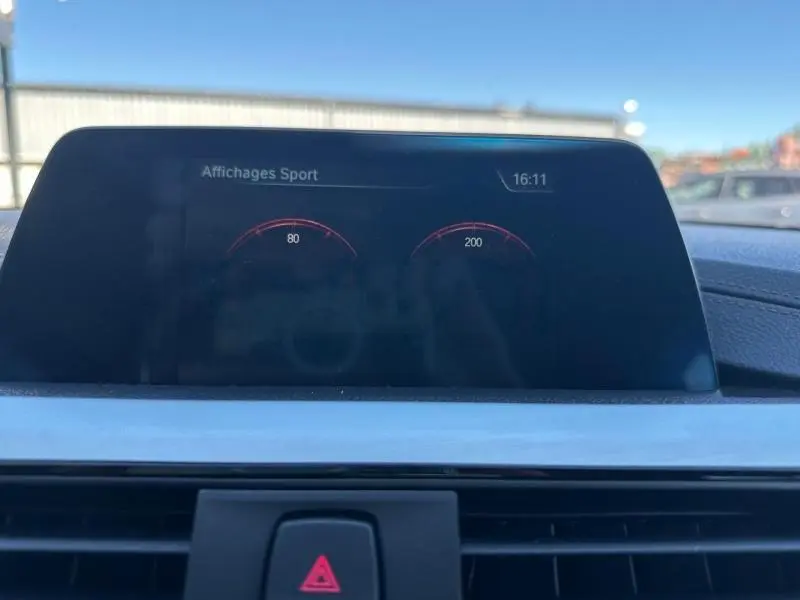 Écran multifonction intérieur de BMW Série 4 Gran Coupe noir affichant les données sportives au centre du tableau de bord.