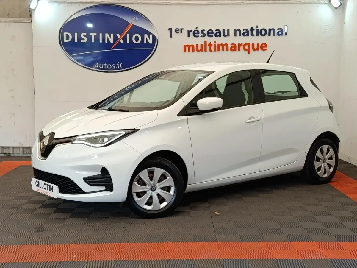 Renault ZOE Business 2021 blanc vue 3/4 avant droit en intérieur avec jantes acier et logo distinctif Renault.