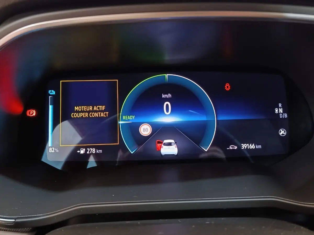 Affichage numérique du combiné d'instruments de la Renault ZOE 2021 avec vitesse, autonomie batterie et alertes visibles.