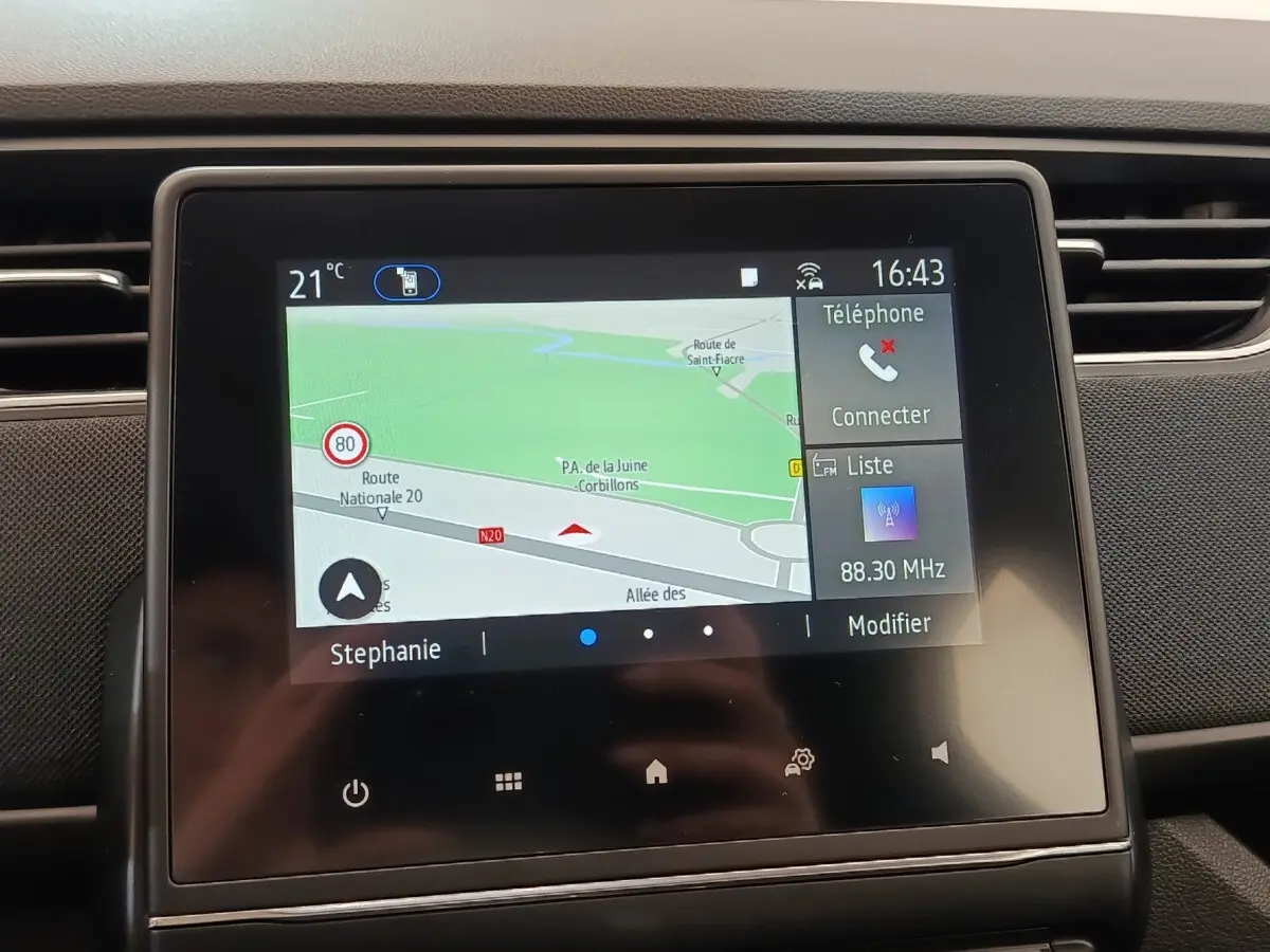 Écran tactile central du tableau de bord de la Renault ZOE blanche 2021 affichant la navigation et les options multimédia.