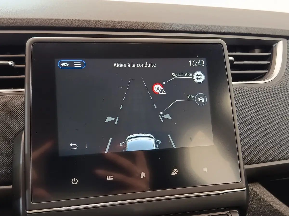 Écran tactile central de la Renault ZOE 2021 blanc affichant l'aide à la conduite avec détection de voie et signalisation.
