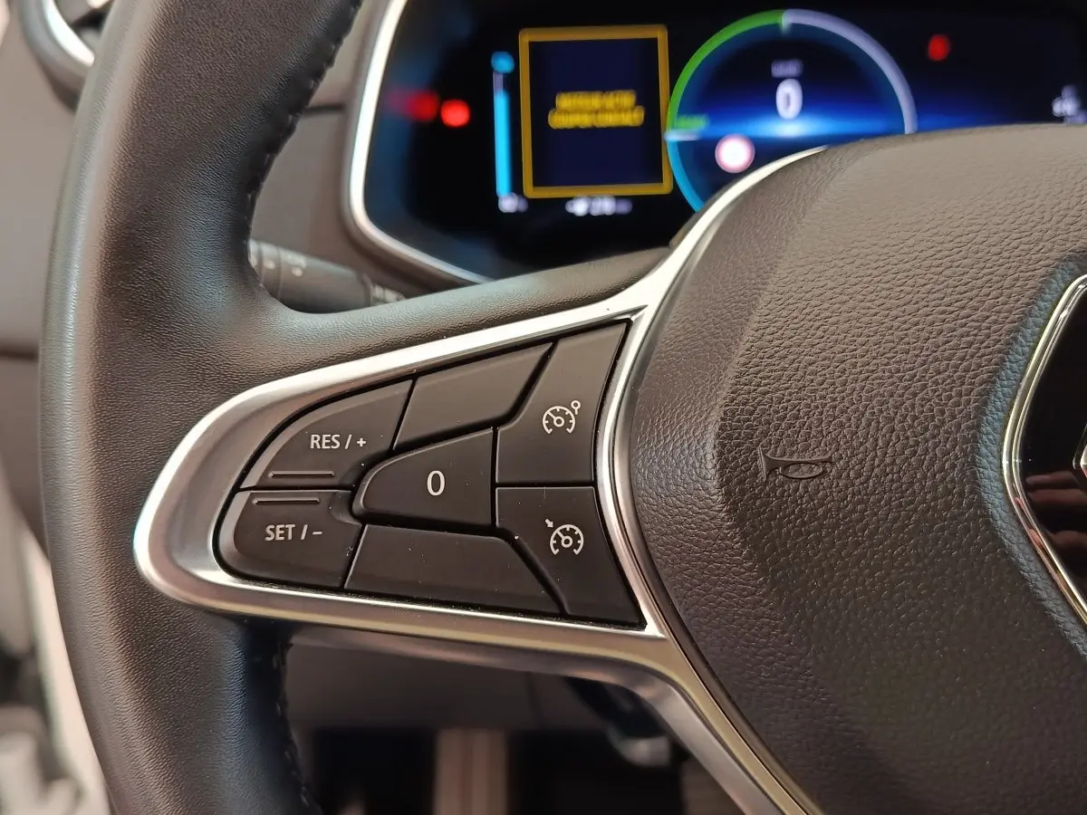 Gros plan sur le volant cuir synthétique noir de la Renault ZOE 2021 avec commandes multifonctions côté gauche.