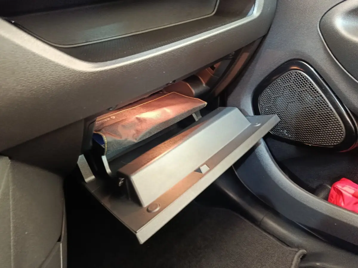 Vue intérieure côté passager montrant la boîte à gants ouverte et le rangement sous siège dans une Renault ZOE blanche 2021.