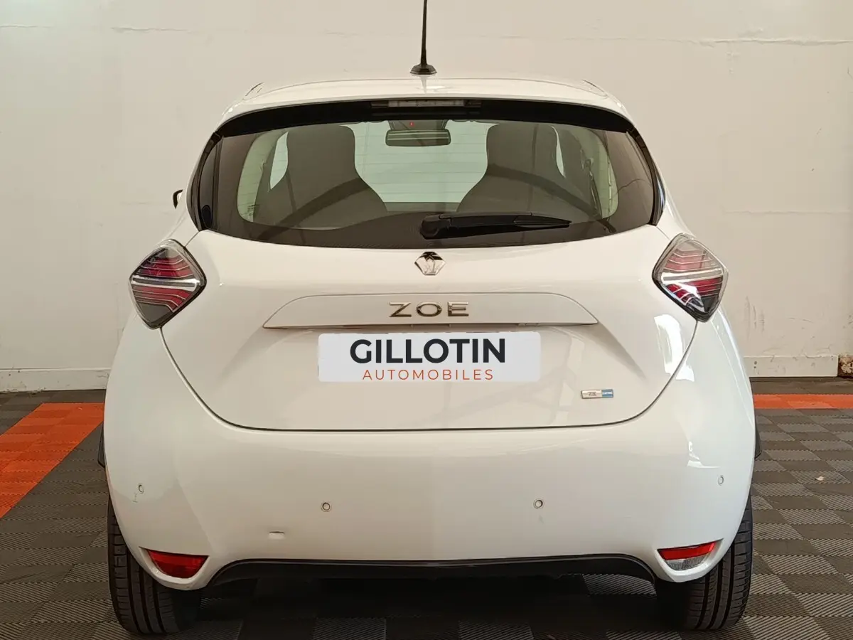 Vue arrière de la Renault ZOE Business blanche de 2021, avec feux arrière distinctifs et logo ZOE visible.