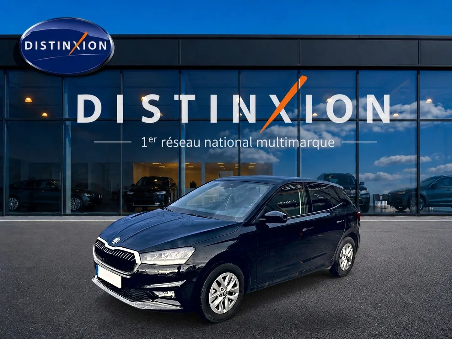 SKODA Fabia noire vue en 3/4 avant droit devant une vitrine avec logo Distinxion.