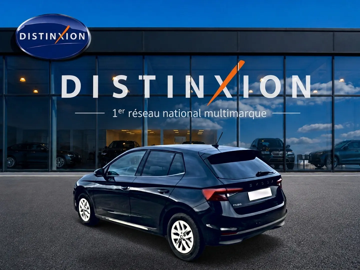 Skoda Fabia noire vue en 3/4 arrière droit, avec jantes alu et vitres arrière teintées devant showroom Distinxion.