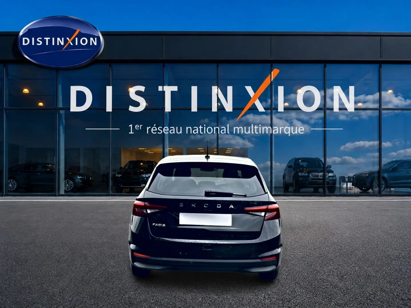 Vue arrière d'une Skoda Fabia noire garée devant une vitrine avec logo Distinxion en arrière-plan.