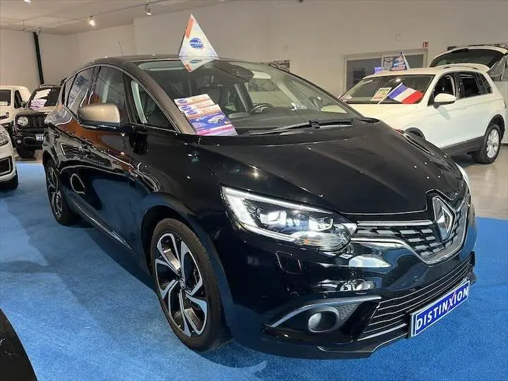 Renault Scenic IV noir étoile métal avec toit gris en 3/4 avant droit dans un showroom lumineux