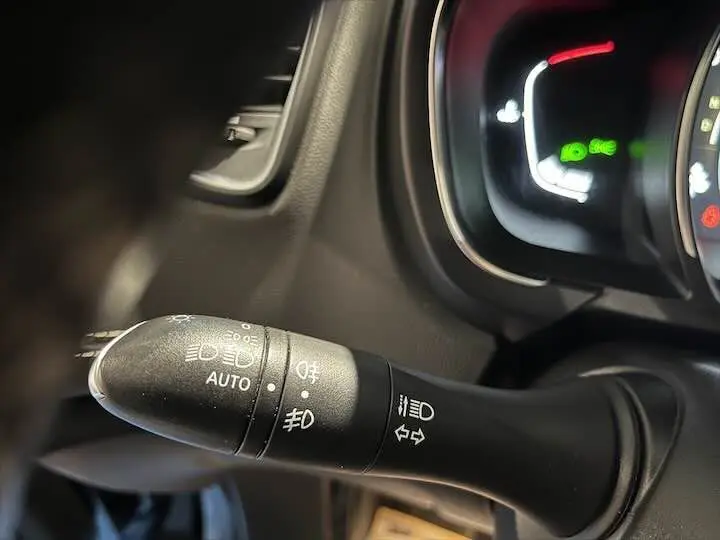 Gros plan sur la commande des phares et clignotants dans l'habitacle d'un Renault Scenic IV noir étoile métal.