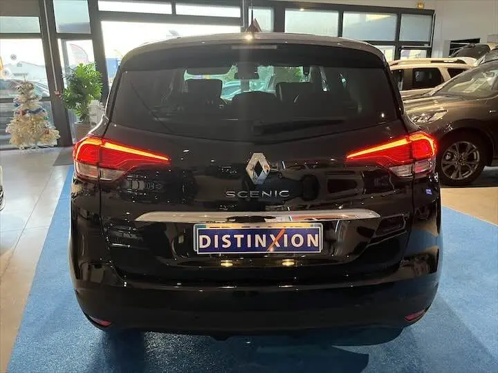 Vue arrière d'un Renault Scénic IV noir étoile métal avec feux LED allumés, exposé en showroom.