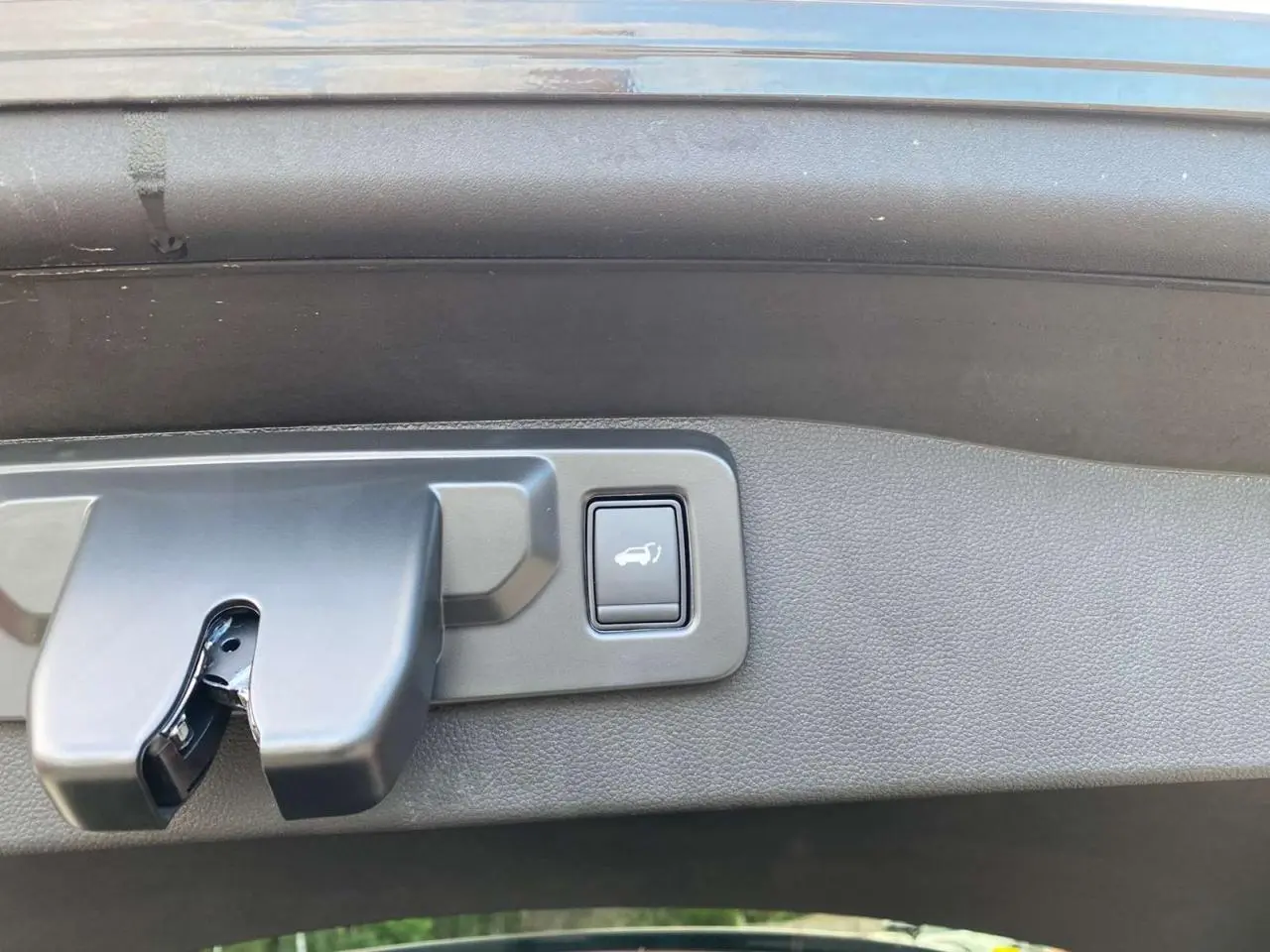 Bouton d'ouverture mains-libres du hayon motorisé sur le coffre d'un Renault Austral noir étoilé 2025.